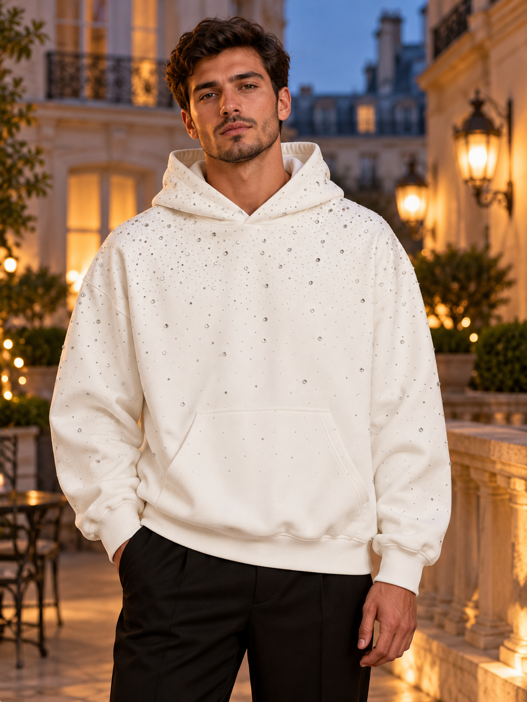 Homme portant le sweat à capuche à strass EYDIZ blanc à Paris, de nuit